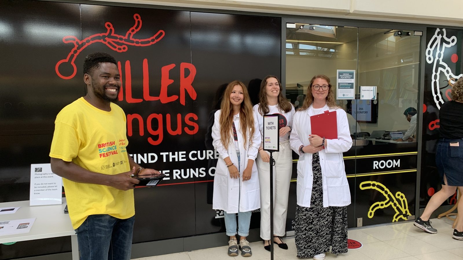People dressed as scientists welcoming visitors to the interactive Killer Fungus activity at The Bristish Science Festival hosted by the University of Exeter in 2023