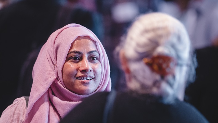 An older and a younger woman talk to each other in a shared space